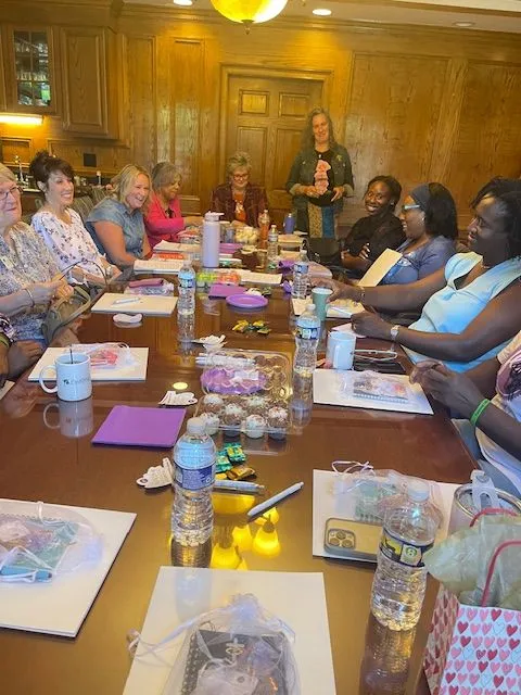 Group of women gathered around a table with materials
